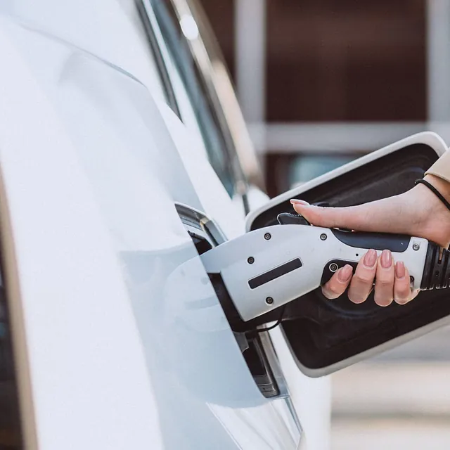 Kvinne setter lader i sin elbil